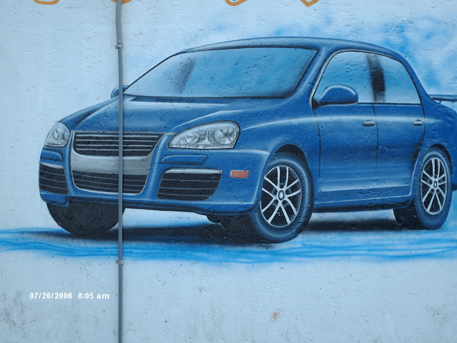 Mural de un carro deportivo azul pintado a mano