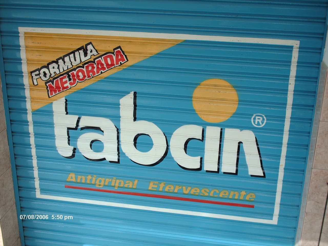 Rótulo de Tabcin pintado a mano en una persiana metálica