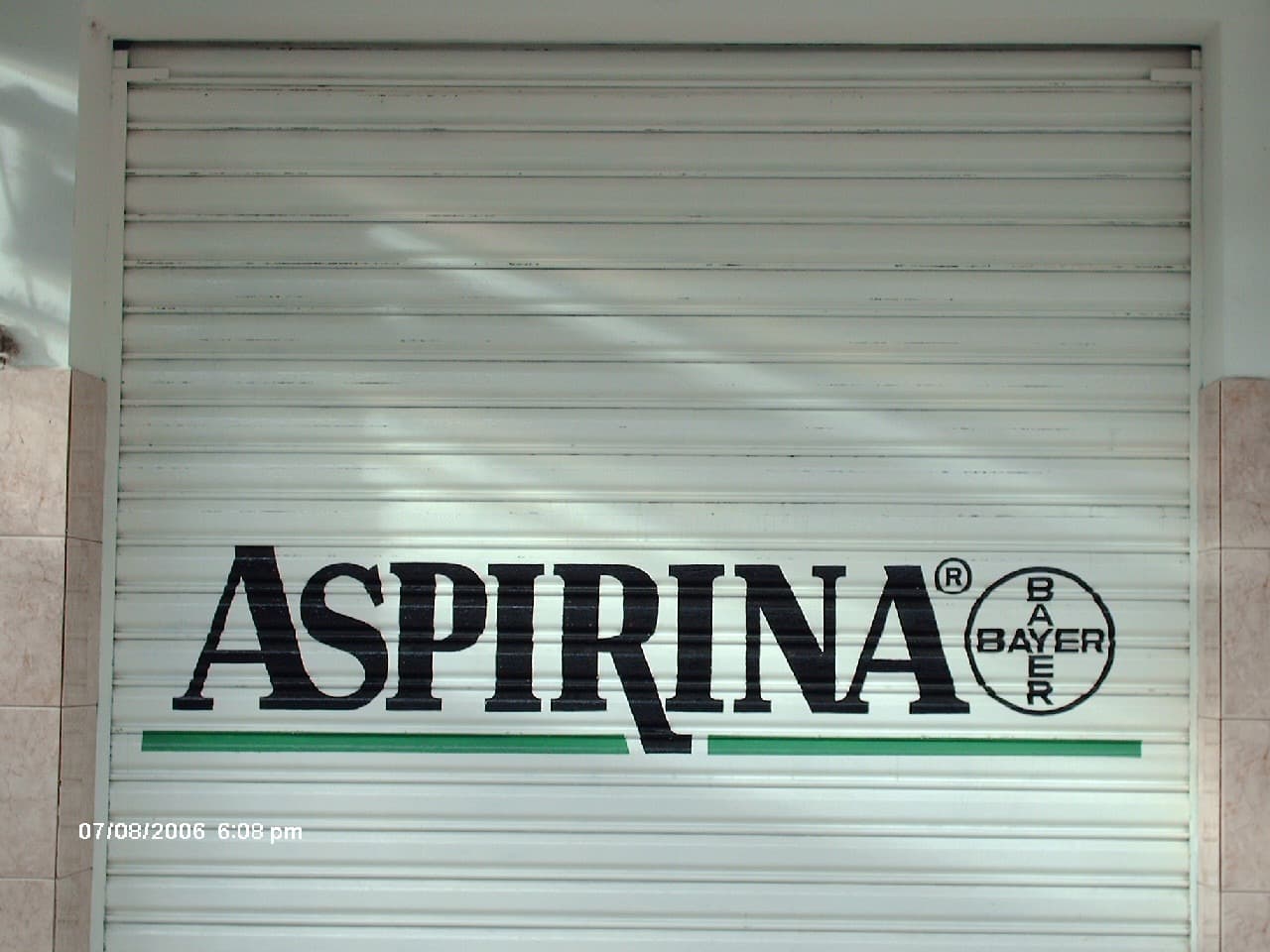 Rotulación de Aspirina y Bayer sobre una persiana de negocio