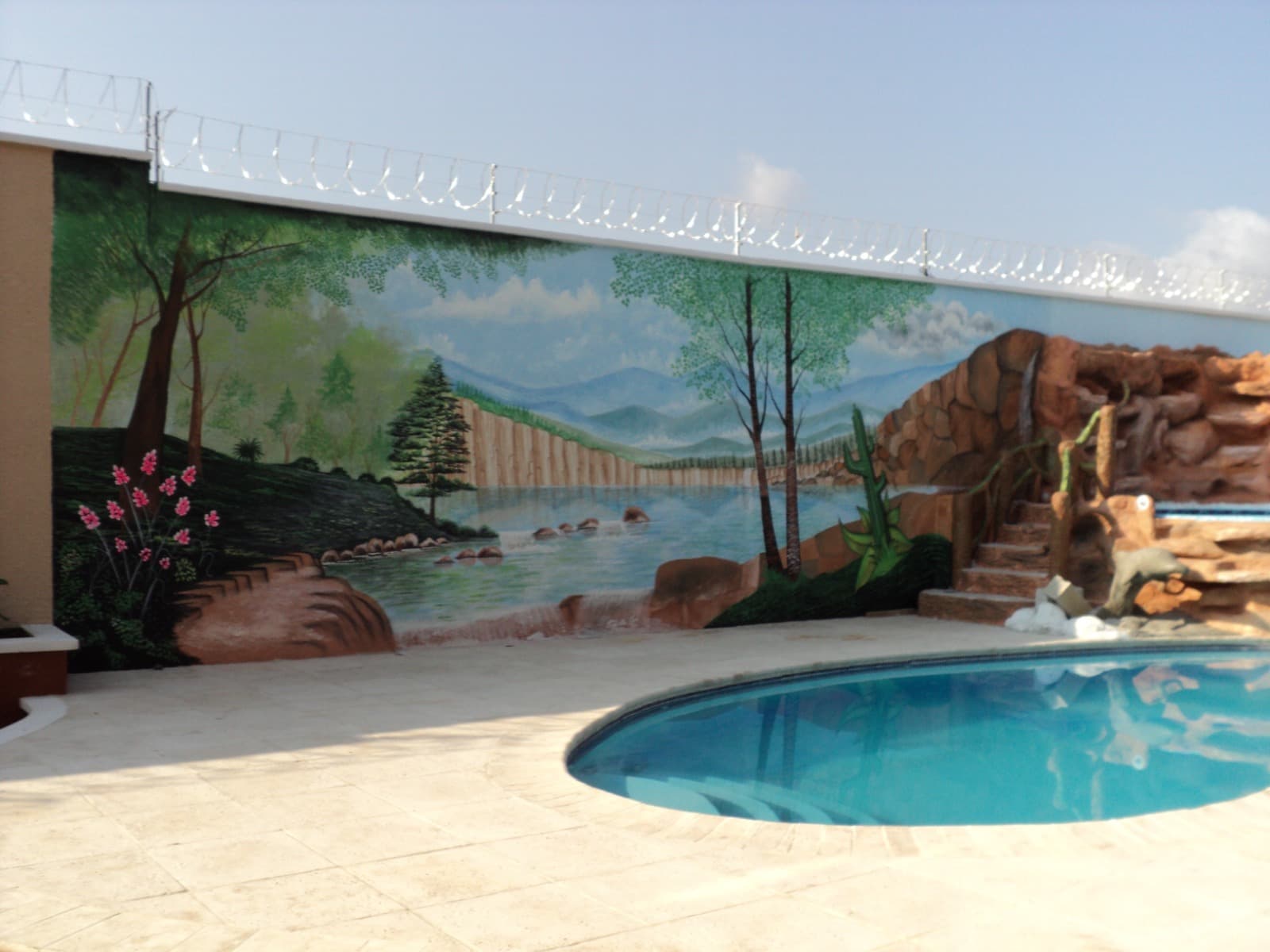 Mural panorámico de un paisaje junto a una piscina